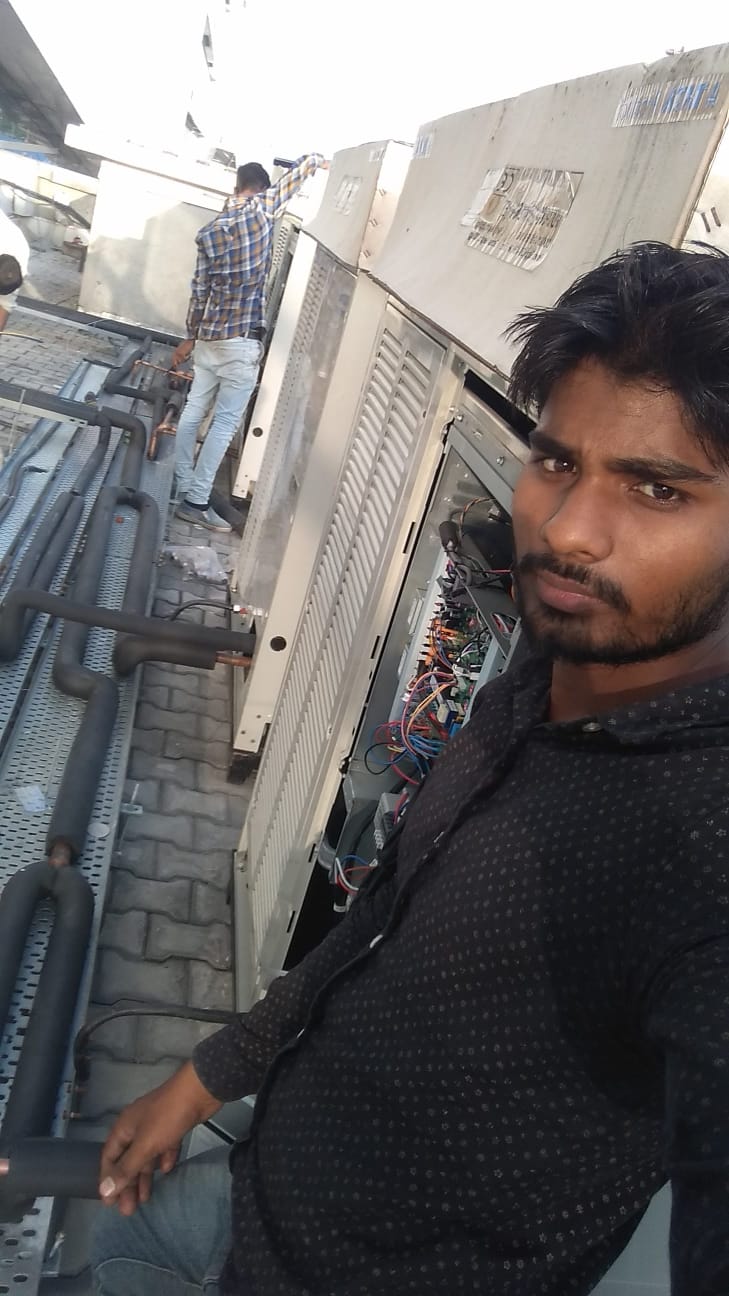 Technician servicing outdoor HVAC equipment